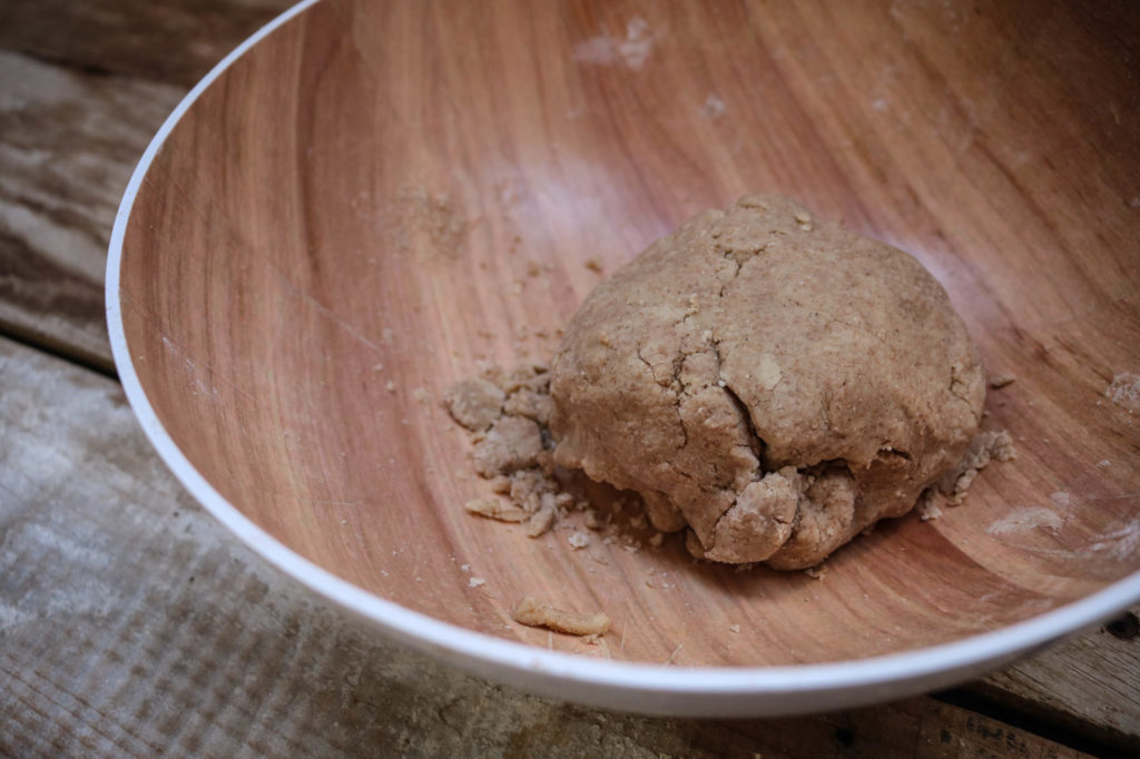 Meng de amandelbloem, gesmolten boter, Erythritol en het vanille extract samen in een mengkom tot een kruimelig deeg