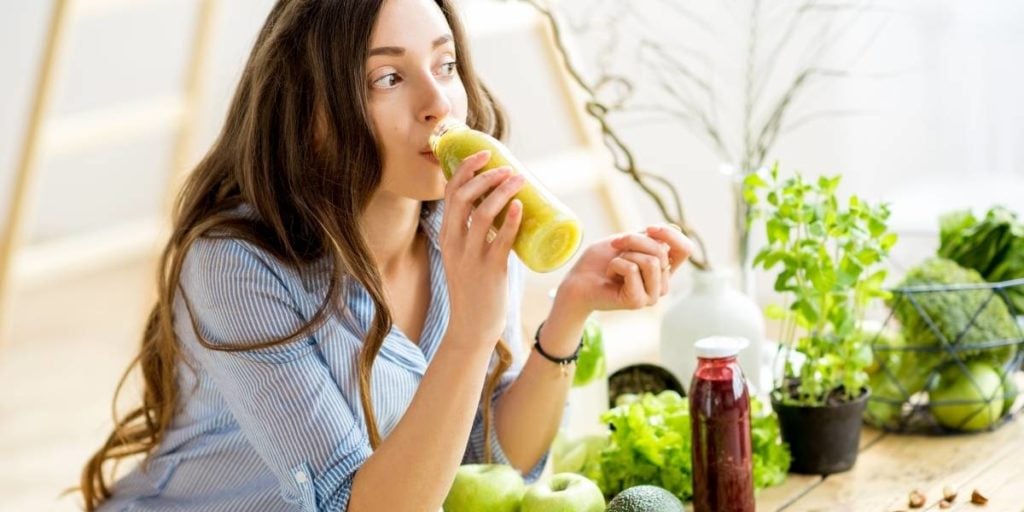 vrouw drinkt een groene smoothie