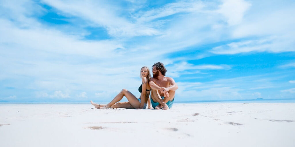 man en vrouw zitten op het strand